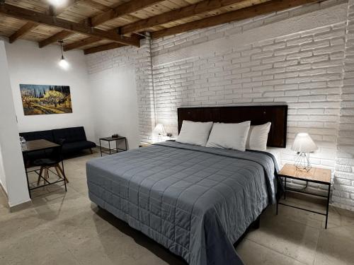 a bedroom with a bed and a brick wall at Casa Ciprés in Valle de Guadalupe