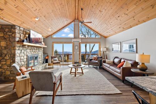 a living room with a stone fireplace and a vaulted ceiling at Wildcat Chalet in Seven Devils