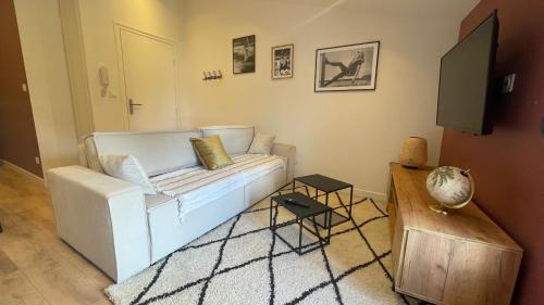 - un salon avec un canapé blanc et une télévision dans l'établissement Le TerraCotta - Appartement tout équipé à Niort, à Niort
