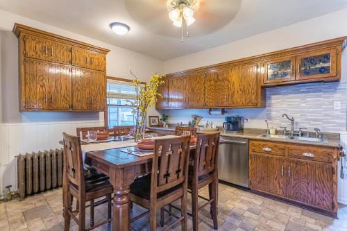a kitchen with wooden cabinets and a wooden table and chairs at Cottage in the City - Historic Charm, Modern Touch in Saint Paul