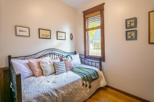 a bedroom with a bed with pillows and a window at Cottage in the City - Historic Charm, Modern Touch in Saint Paul