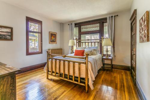a bedroom with a bed and two windows at Cottage in the City - Historic Charm, Modern Touch in Saint Paul