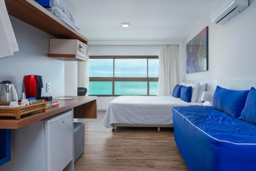 a bedroom with a bed and a couch in a room at Hotel Ponta Verde Maceió in Maceió