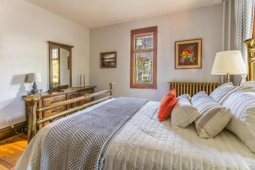 a bedroom with a large bed with pillows on it at Cottage in the City - Historic Charm, Modern Touch in Saint Paul