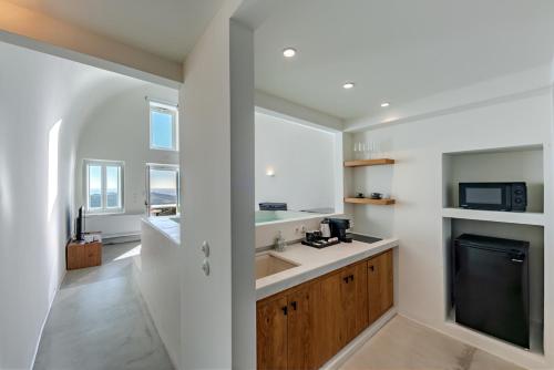 a kitchen with a sink and a microwave at Thera Villas in Fira