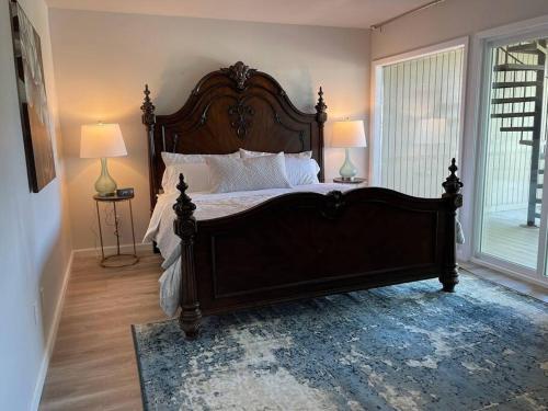 - un grand lit en bois dans une chambre avec deux lampes dans l'établissement Lake Travis Oasis, Walk to Pool, Gym, Marina, Food, à Leander