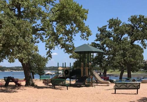a park with a playground with a slide and trees at Lake Travis Oasis next to Pool, Marina, Boat ramp in Leander