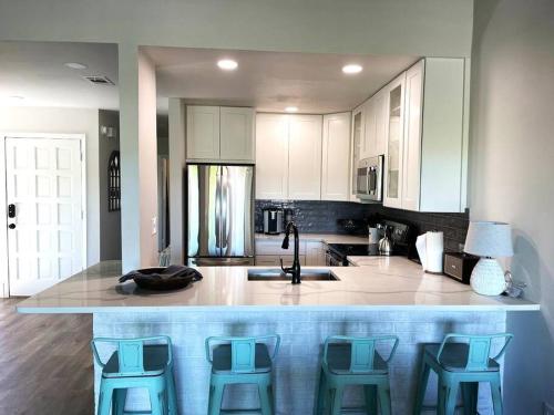 a kitchen with a large island with blue bar stools at Lake Travis Oasis next to Pool, Marina, Boat ramp in Leander