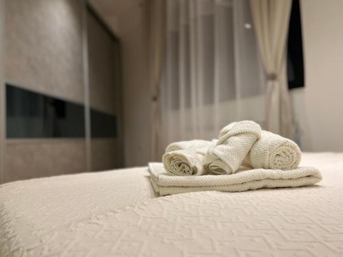 uma pilha de toalhas sentadas em cima de uma cama em Maria's Elite Luxury Apartment Skopje em Skopje