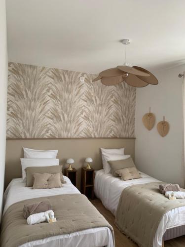 une chambre avec deux lits et un ventilateur de plafond dans l'établissement Gîte avec jacuzzi 6 personnes, à Brouchaud