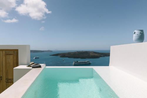 a swimming pool with a view of the ocean at Thera Villas in Fira