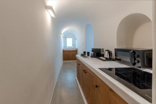 a kitchen with a counter top with a microwave at Thera Villas in Fira