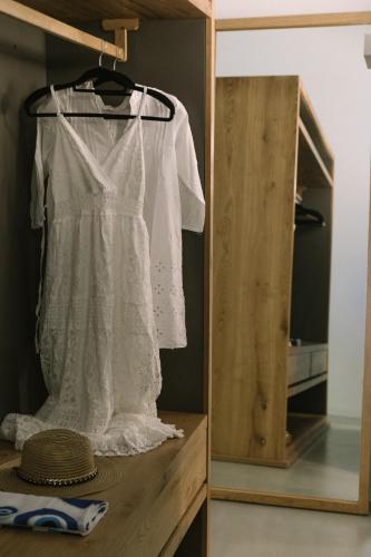 a white dress hanging on a rack in a room at Thera Villas in Fira