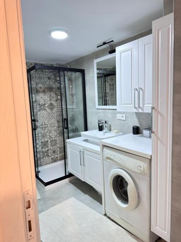 a bathroom with a washing machine and a sink at an apartment in a decent neighborhood in Karşıyaka