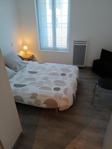 um quarto com uma cama e uma janela em Appart Foch T1 em Langogne