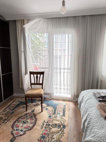 1 dormitorio con 1 cama, 1 silla y 1 ventana en an apartment in a decent neighborhood en Karşıyaka