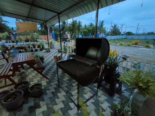 a patio with a grill and some potted plants at Victory's Gardens in Mannar