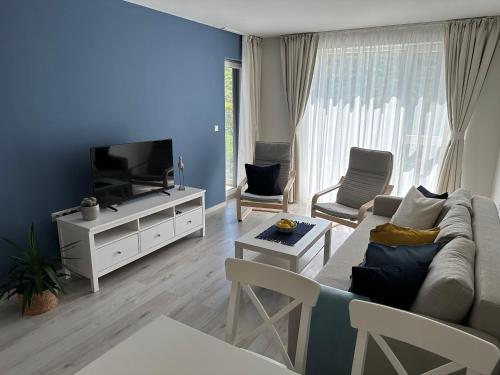 ATEA Apartments في كافارنا: غرفة معيشة مع أريكة وتلفزيون