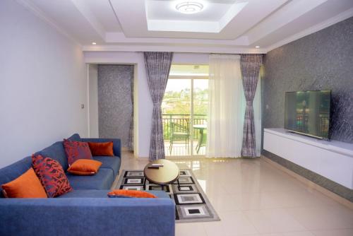 sala de estar con sofá azul y TV en Grazia Apartments en Kigali