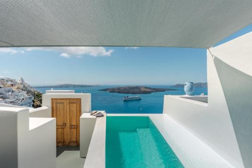 a view from the balcony of a house with a swimming pool at Thera Villas in Fira