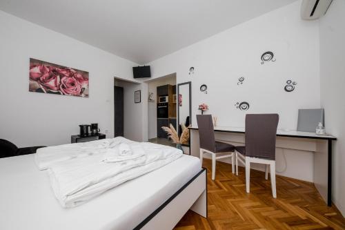 a bedroom with a bed and a table and chairs at Apartmani Ana & Milo in Lopar