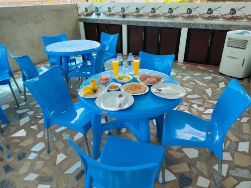 a blue table and chairs with food on it at Victory's Gardens in Mannar