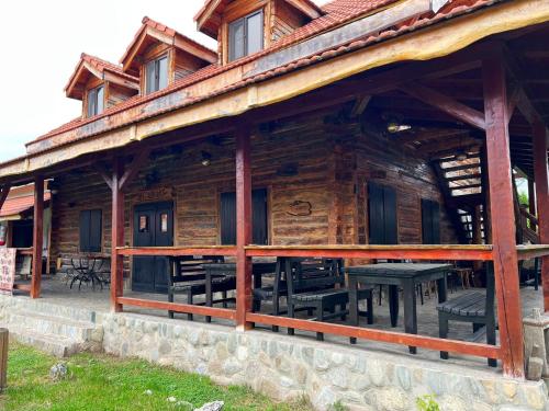a log cabin with a picnic table in front of it at Satul Traditional in Runcu