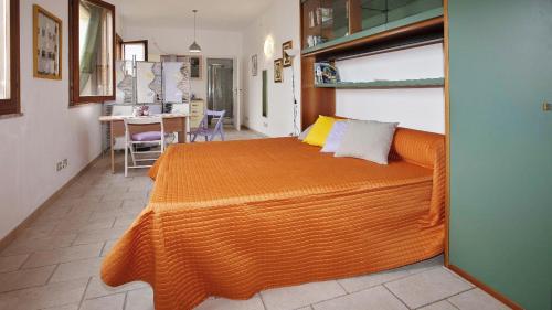 una camera con un grande letto arancione di Lovely Studio in Pula a Pula