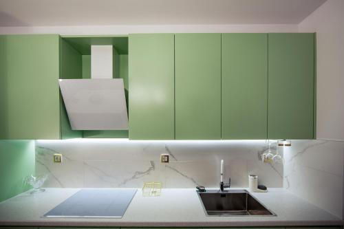 a kitchen with green cabinets and a sink at Businka in Ravda