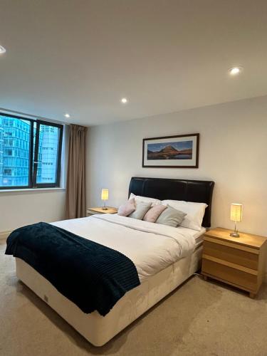 um quarto com uma cama grande e 2 mesas de cabeceira em New Beautiful Lux Apartment em Londres