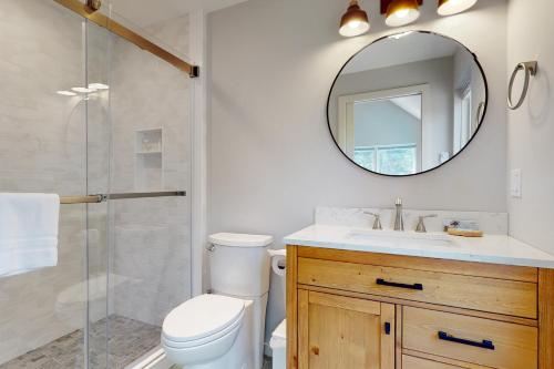 a bathroom with a toilet and a sink and a mirror at Tree House at Harts Neck in Saint George