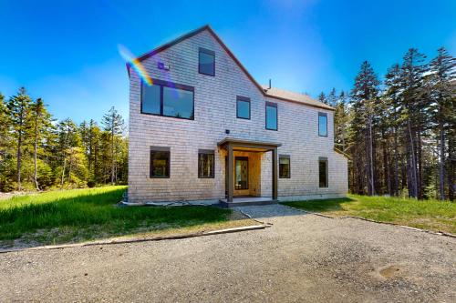 a large white house on a hill with trees at Tree House at Harts Neck in Saint George
