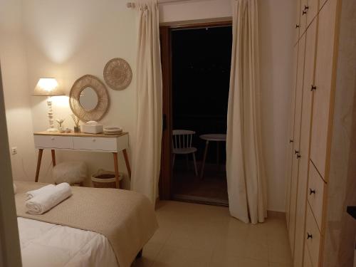 a bedroom with a bed and a mirror and a window at Ammos Aetos apartment in Karistos