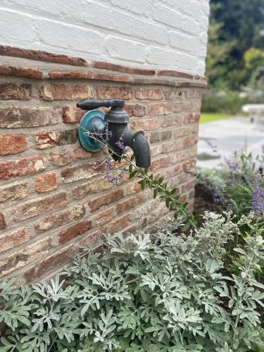 a water meter on the side of a brick wall at VAKANTIEWONING HUYZE ANNE MARIA in Damme