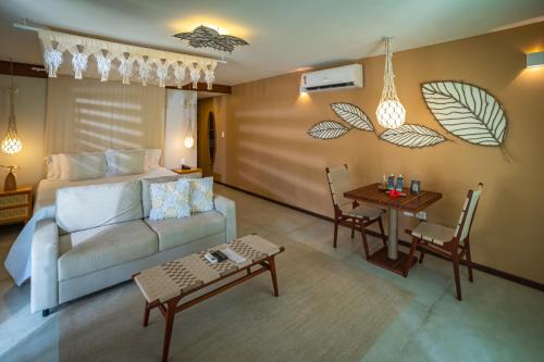 uma sala de estar com um sofá e uma mesa em Pontal dos Carneiros Beach Bungalows em Praia dos Carneiros