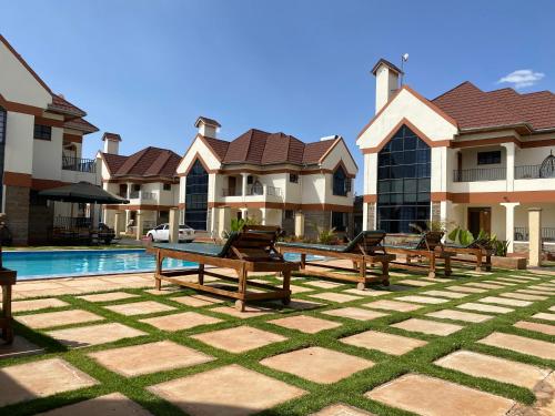 a group of benches in front of a house at Lifestyle Villas, Nanyuki in Nanyuki