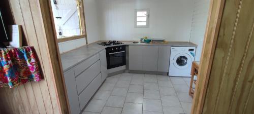 a kitchen with a stove and a washing machine at fleurs de canne in Petit-Bourg