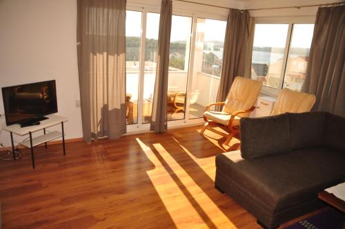 a living room with a couch and chairs and a television at Guest House Stefica in Hvar