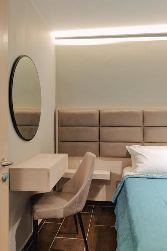 a bedroom with a bed and a desk and a mirror at Casa Del Mar in Ksamil