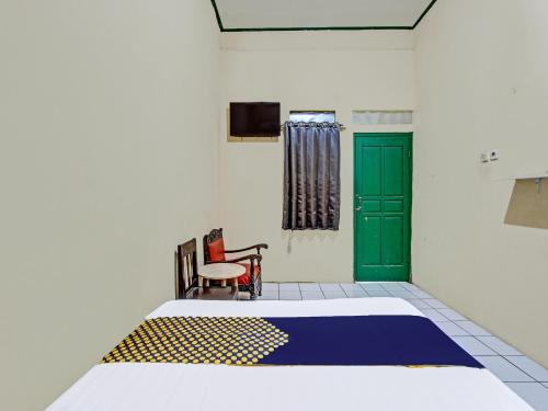ein Schlafzimmer mit einem Bett und einer grünen Tür in der Unterkunft SPOT ON 92009 Hotel Indah Arum 
