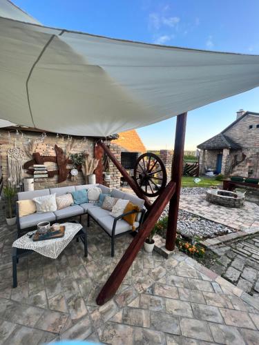 a white umbrella on a patio with a couch at Salaš kod Bobana in Bač