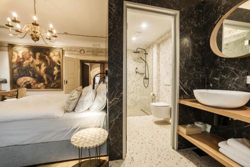 a bathroom with a bed and a sink and a mirror at Hotel Pok Garni in Brezovica