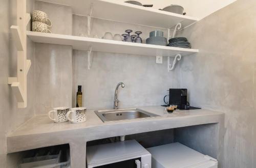 a kitchen with a sink and some cups and mugs at Afluencia Complex Studio No 4,5,6 in Naousa