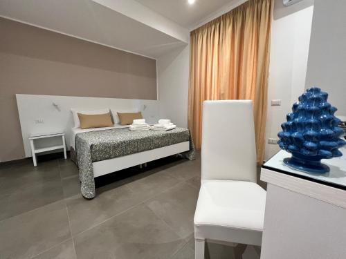 a bedroom with a bed and a white chair at Anfitrite B&B Tropea in Tropea