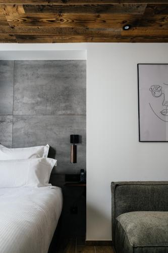 a bedroom with a white bed and a couch at Auberge du Lyonnais in Annecy