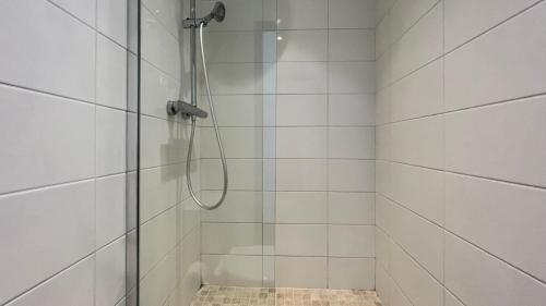 une salle de bain avec une douche avec une porte vitrée dans l'établissement L'écrin de Saint-Cyr, à Nevers