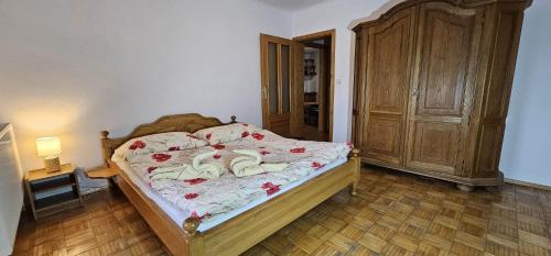 1 dormitorio con 1 cama y armario de madera en Penzion Ustie, en Trstená