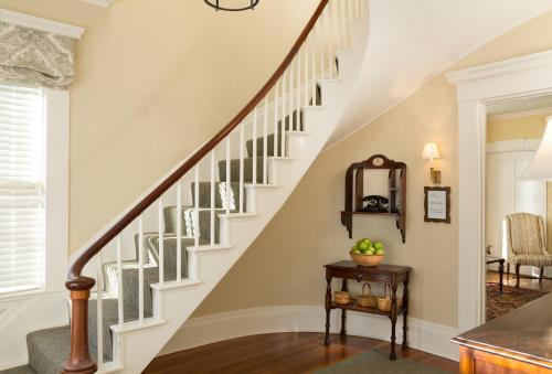 a staircase in a home with white walls at Brass Lantern Inn in Nantucket