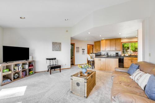 a living room with a couch and a kitchen at Hubbard Hill Haven in La Conner