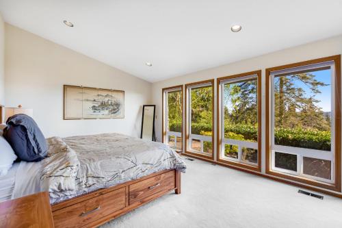a bedroom with a bed and large windows at Hubbard Hill Haven in La Conner